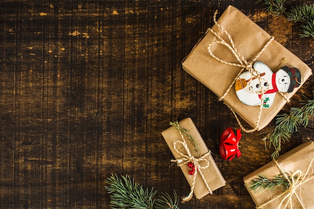 Cloches et branches de conifères près de cadeaux