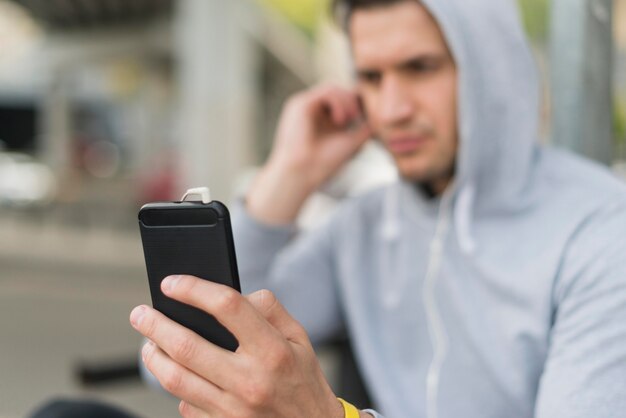 Close-up adult man parcourant son téléphone portable