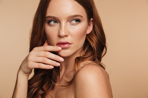 Close up Beauty portrait of mystery gingembre femme aux cheveux longs posant sur le côté tout en regardant loin