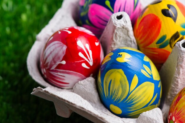 Close-up de la boîte à œufs avec des oeufs de Pâques sur la surface de l&#39;herbe