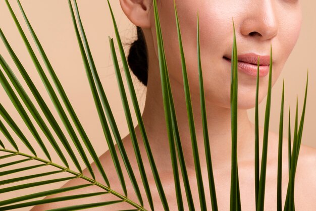 Close-up brunette fille posant avec des feuilles