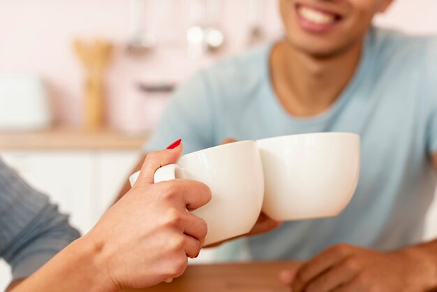 Close-up couple heureux avec des tasses à café