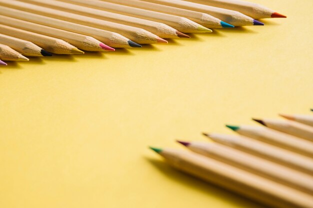 Close-up de crayons multicolores sur fond jaune