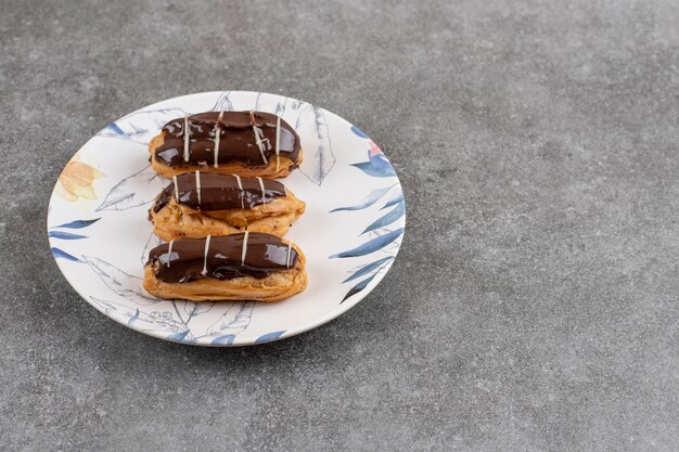 Close up d'éclairs au chocolat frais sur la plaque