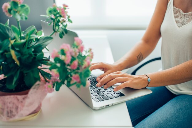 Close-up de l&#39;employé en utilisant l&#39;ordinateur portable à côté d&#39;une plante