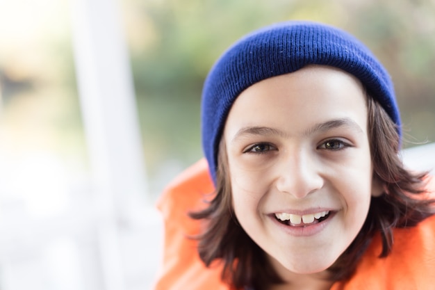 Photo gratuite close-up de l'enfant gai avec capuchon en tricot et gilet de sauvetage