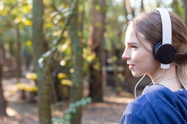 Close-up de la femme blonde avec un casque extérieur