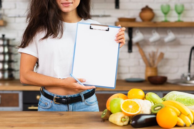 Close-up femme brune tenant un presse-papiers