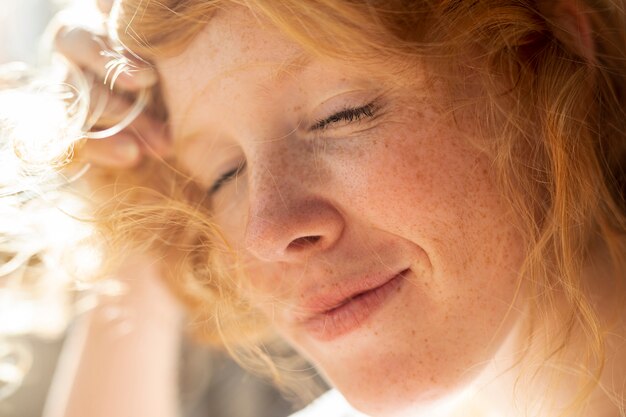 Close-up femme rousse aux yeux fermés