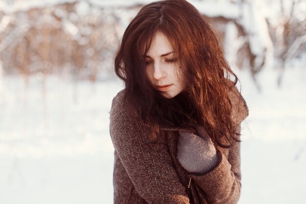 Close-up de la femme timide posant dans la neige