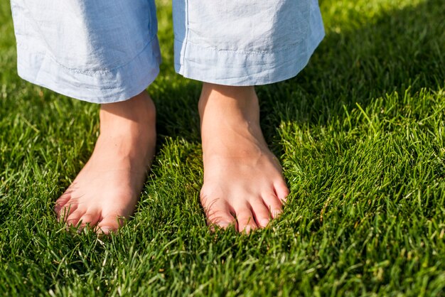 Close-up fille aux pieds nus, debout sur l'herbe