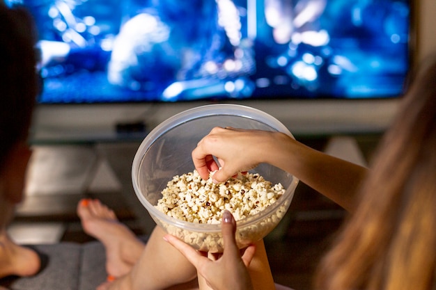 Close-up gens mangeant du pop-corn dans le salon