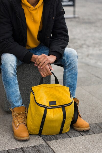 Close-up guy assis avec sac à dos jaune