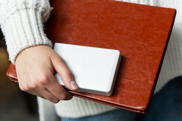 Close up hand holding notebook et ssd