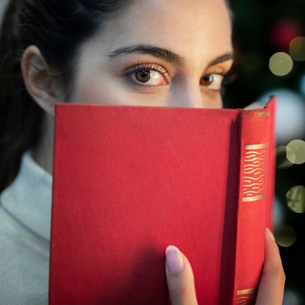 Close-up jeune femme couvrant le visage avec un livre