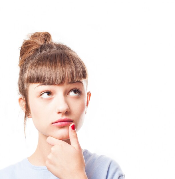 Close-up d&#39;une jeune fille pensive avec une frange toucher son menton