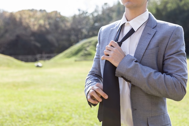 Photo gratuite close-up d'un jeune homme tenant sa cravate après le travail