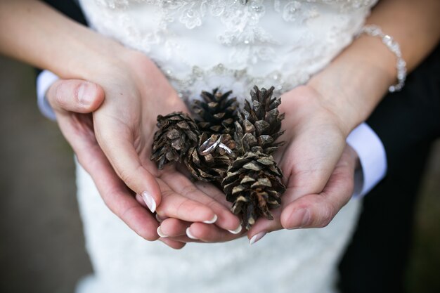 Close-up de jeunes mariés tenant pinecones