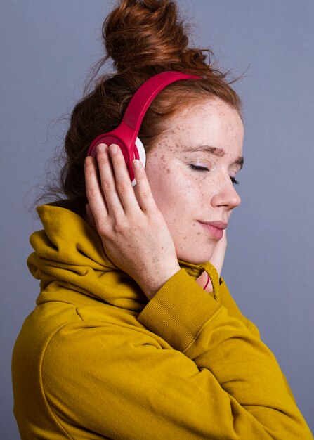 Close-up jolie femme avec un casque et capuche jaune