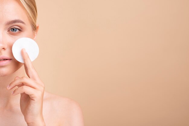 Close-up jolie femme avec un tampon de coton et copie-espace