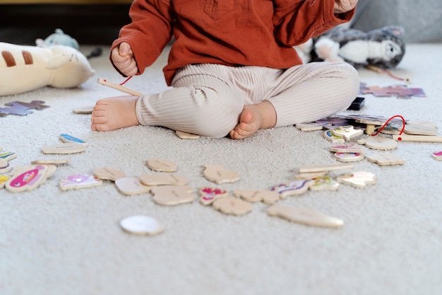 Photo gratuite close up kid avec des jouets en bois sur le sol