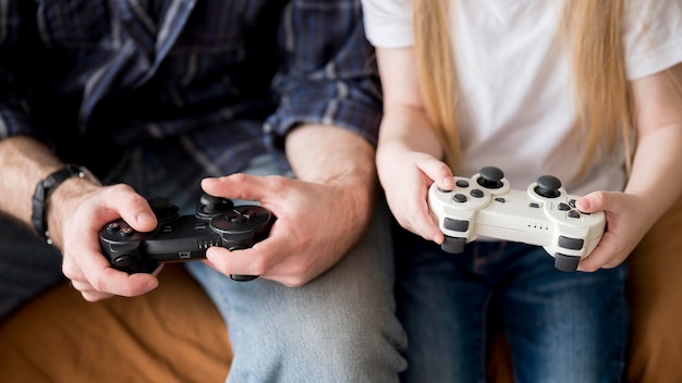 Photo gratuite close-up kid et père jouant avec joystick