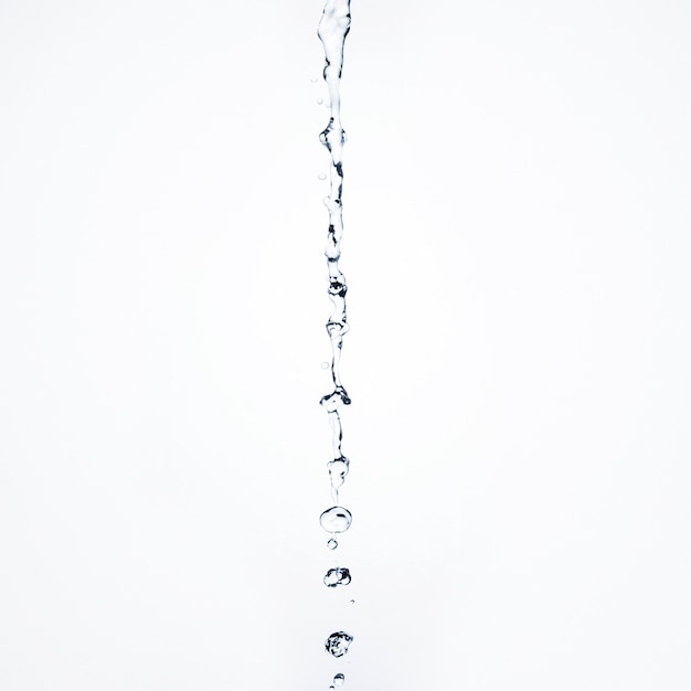 Photo gratuite close-up liquide transparent qui coule sur fond blanc