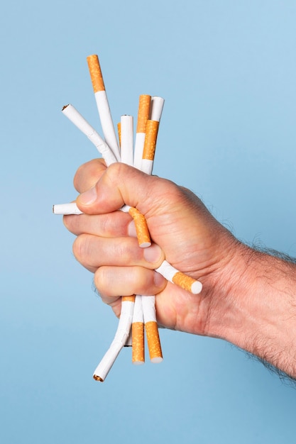 Close-up main serrant les cigarettes