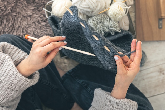 Photo gratuite close-up de mains féminines tricotant un pull en laine grise vue supérieure