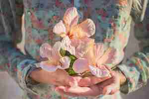 Photo gratuite close-up des mains avec des fleurs