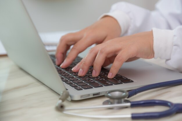 Close-up des mains de typage du médecin