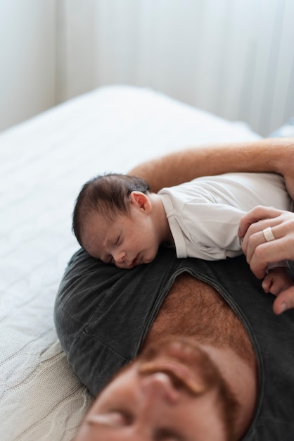 Close-up père dormir avec son bébé