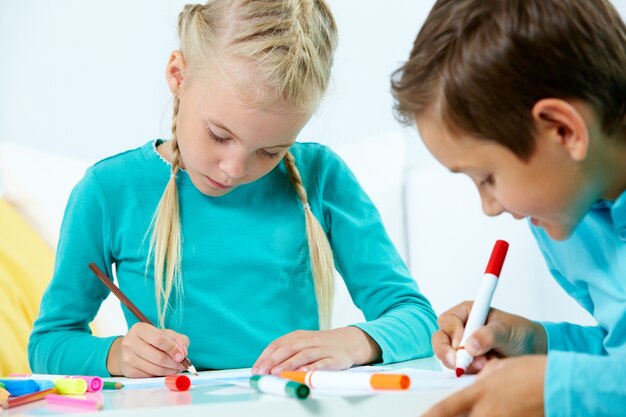 Close-up de petit garçon avec un crayon rouge