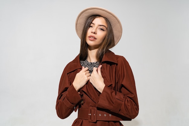 Close up portrait de mode studio intérieur de femme magnifique en manteau marron d'hiver élégant et chapeau noir