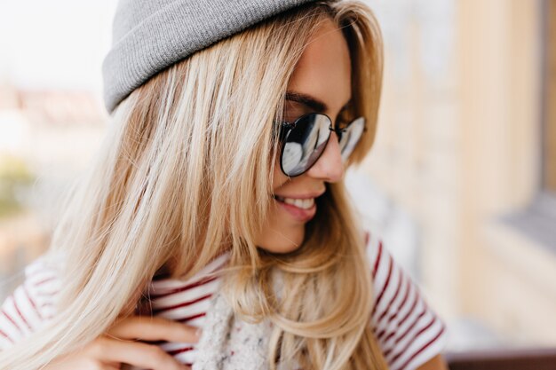 Close-up portrait of enchanteur modèle féminin blond à la voiture avec joli sourire