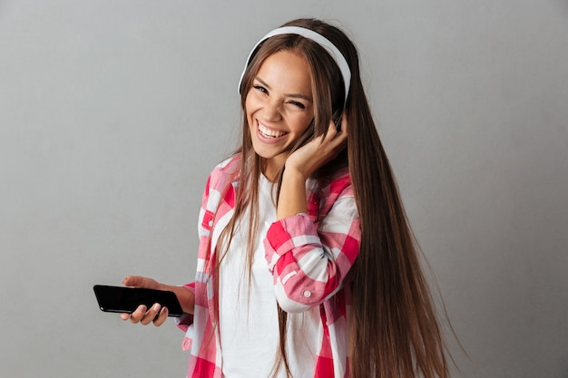 Close-up portrait of young laughing pretty woman in headphones écouter de la musique