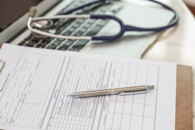 Close-up de presse-papiers avec un stylo et un stéthoscope fond