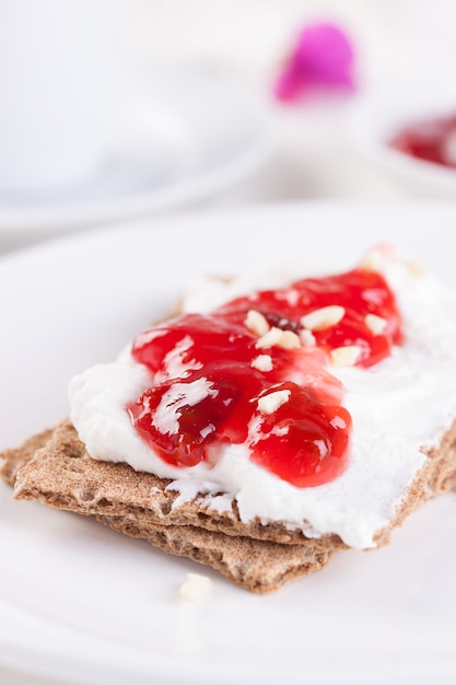 Close-up de la savoureuse confiture de fraises avec des toasts croustillants