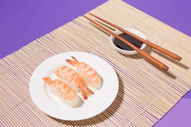 Close-up sushi et sauce soja avec des baguettes