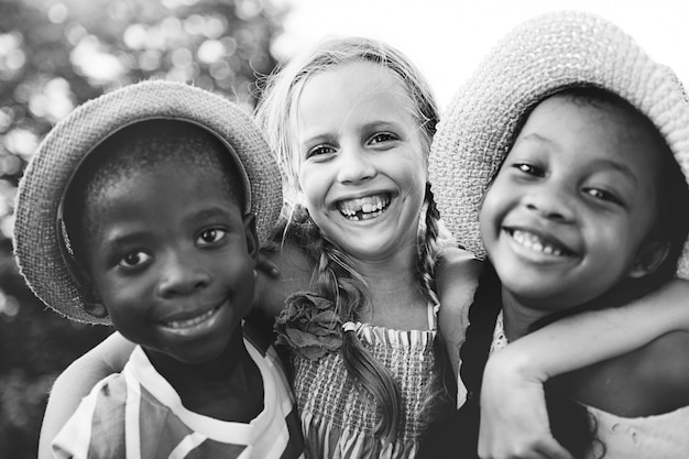 Closeup groupe de divers enfants souriants en niveaux de gris
