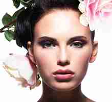 Photo gratuite closeup portrait de la belle jeune femme avec des fleurs roses dans les cheveux - isolé sur blanc
