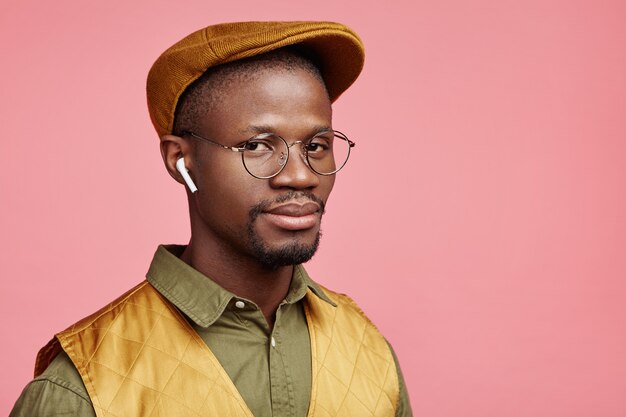 Closeup portrait de jeune homme afro-américain avec chapeau et écouteurs sans fil