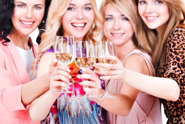 Closeup portrait de jeunes femmes heureuses ont la fête et boire du vin - isolé sur blanc