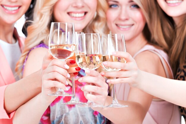 Closeup portrait de jeunes femmes heureuses ont la fête et boire du vin - isolé sur blanc