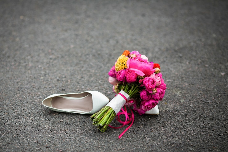 Photo gratuit closeup shot de chaussures de mariage blanc élégant et un bouquet frais