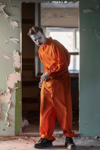 Clown effrayant plein coup dans un bâtiment abandonné