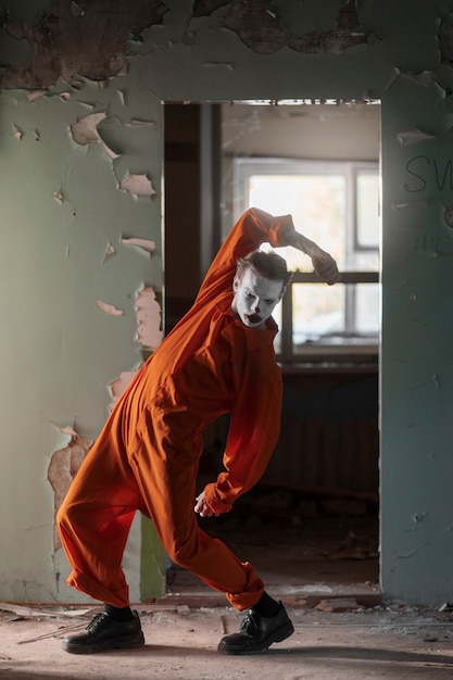 Photo gratuite clown effrayant plein coup dans un bâtiment abandonné