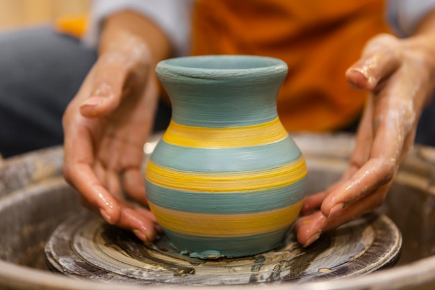 Clsoe les mains faisant de la poterie
