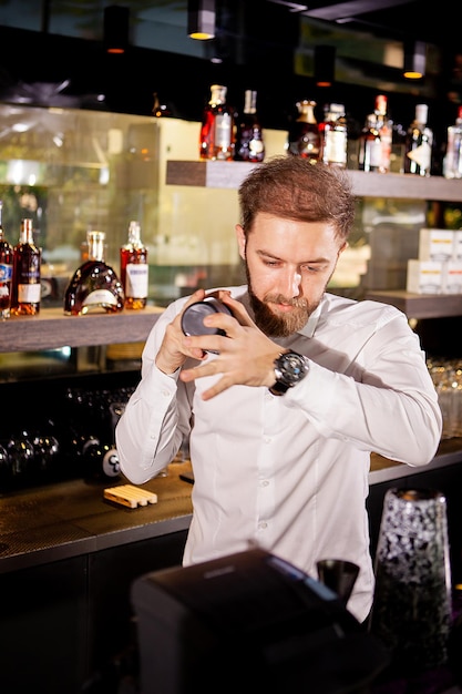 Cocktail alcoolisé au bar. Le barman prépare un cocktail alcoolisé. Boisson délicieuse