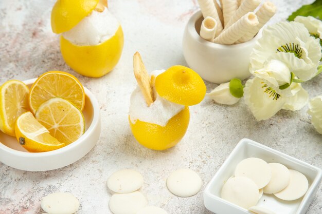 Cocktail au citron vue de face avec des biscuits sur un cocktail d'agrumes de jus de table blanc